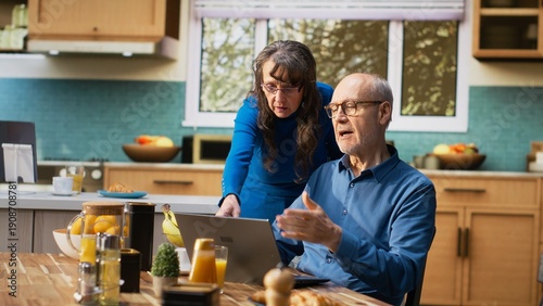 Canvas-taulu Unhappy distressed old man finding bad disappointing new on laptop, his elderly wife is consoling him and being supportive