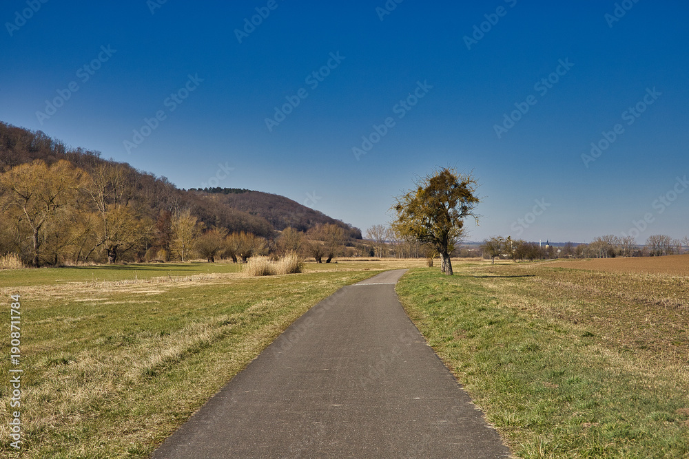 Obraz premium Idyllischer Unstrutradweg mit Blick auf die Landschaft und Wohnhäuser bei strahlend blauem Himmel, zwischen Freyburg und Laucha, Burgenlandkreis, Sachsen-Anhalt, Deutschland