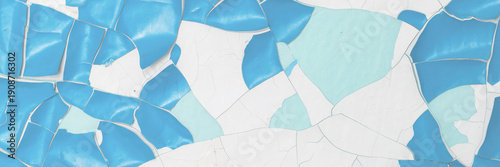 Blue peeling paint on the wall. Old concrete wall with cracked flaking paint. Weathered rough painted surface with patterns of cracks and peeling. High resolution texture for background and design.