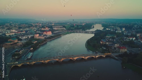 Aerial view of a tram crossing the Augustus Bridge over the Elbe River in Dresden's Old Town at dawn