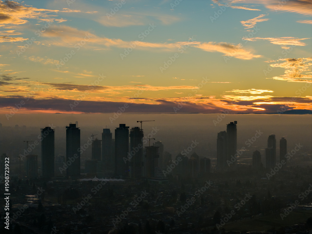 Fototapeta premium Sunset Over Burnaby Skyline: High Rise Buildings Frame A Golden Horizon Over The City