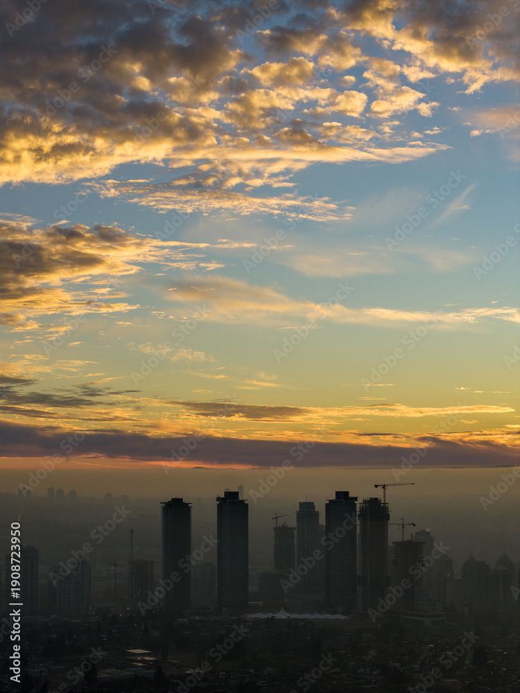 Fototapeta premium Dramatic Sunset Over Burnaby Skyline With Cranes And City Silhouette In Canada