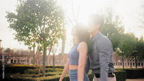 Romantic hispanic couple dancing bachata in a park at sunset