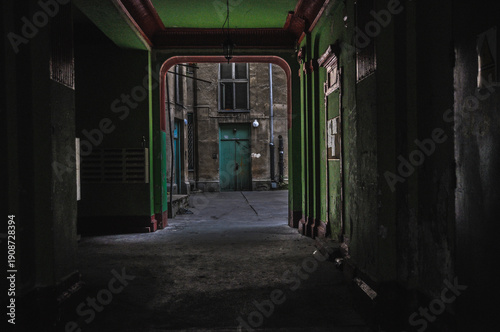 The gate of an abandoned building, green walls, green doors, old tenement building
