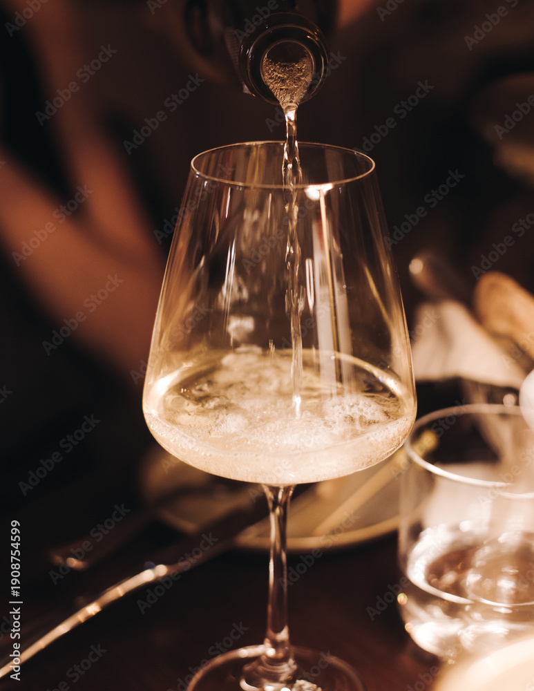 Obraz premium Group of guests celebrate and raise glasses, toasting and cheering with alcohol glasses with wine and champagne in the restaurant on corporate christmas birthday party event or wedding celebration