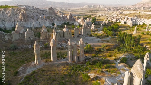 Goreme, Nevsehir, Turkey. Intimate low flight over Love Valley trails with close view of unique rock formations during golden hour. Aerial View