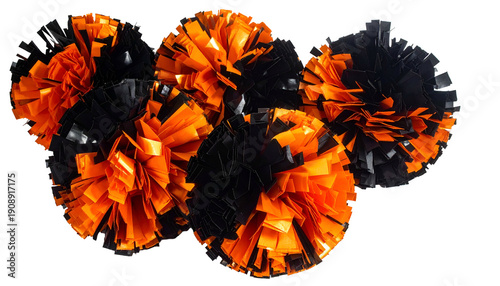 Close-up of several orange and black cheerleading pom-poms clustered together against black