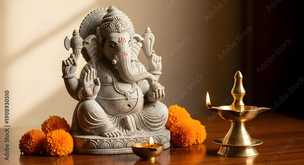 Obraz premium Stone Ganesha statue with marigold flowers and lit brass oil lam