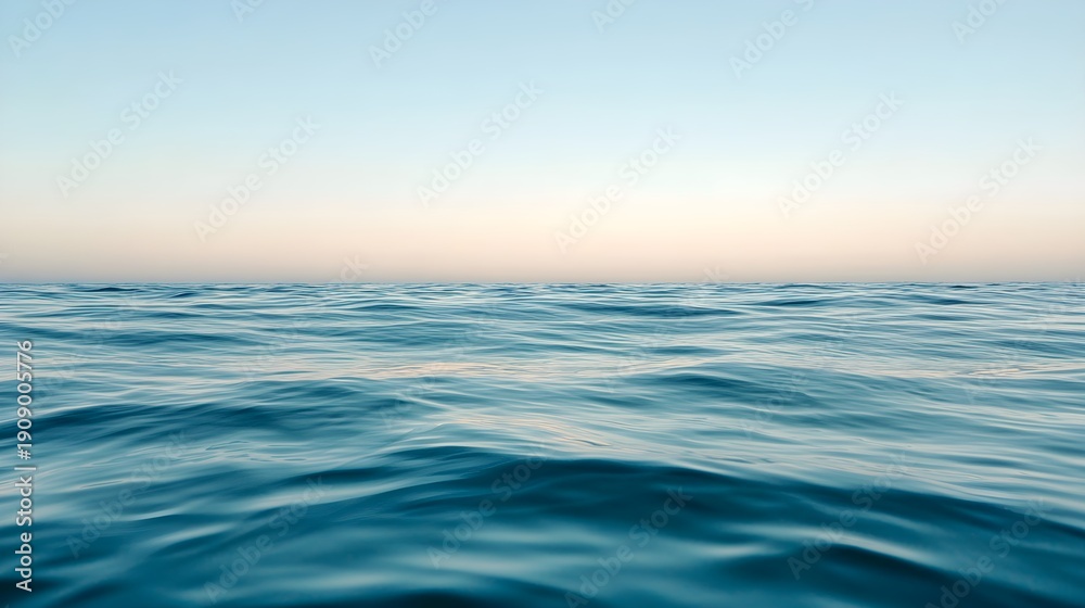 Obraz premium Calm ocean surface at sunrise with soft sky gradient