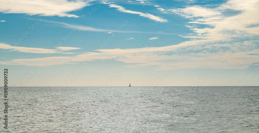 Fototapeta premium Sea with calm summer sky background. Sea with soft clouds. Sea calm tranquil water. Sea quiet background.