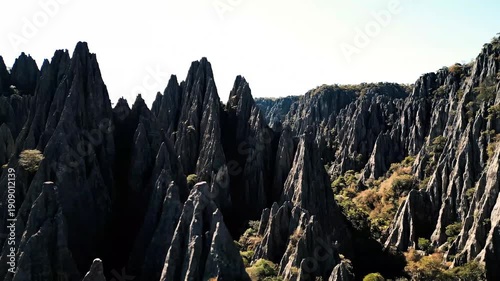 Cinematic aerial flight over sharp limestone karst peaks in Tsingy de Bemaraha national park showing rugged geologic formations