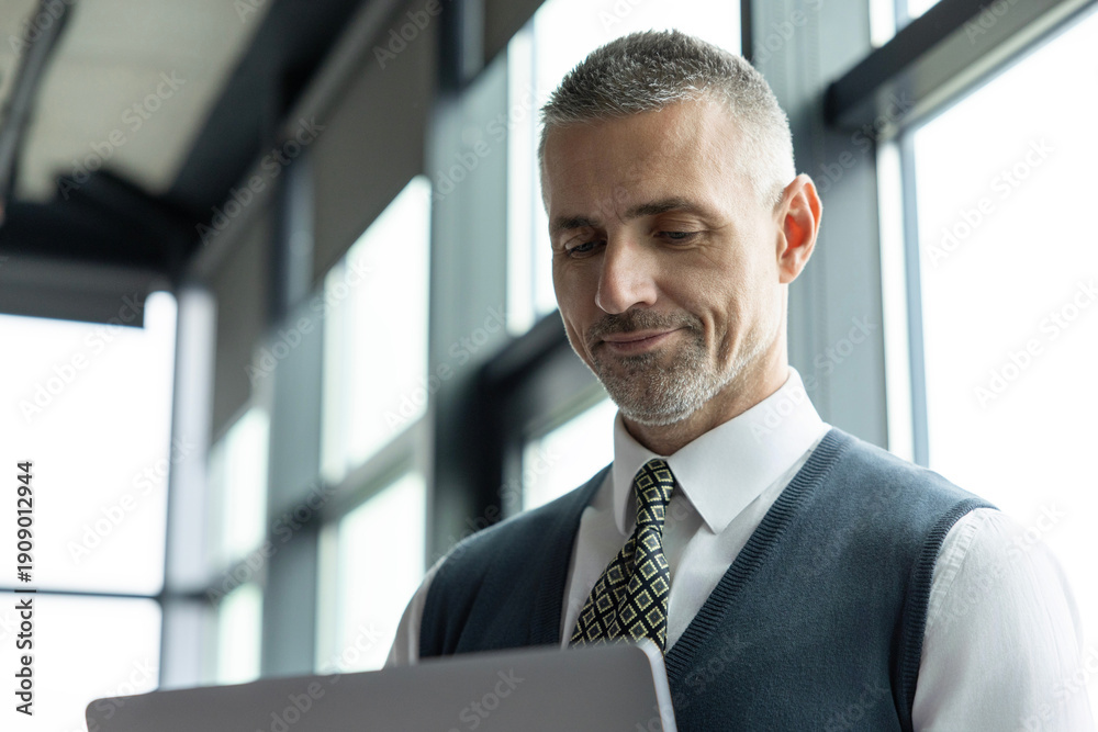 Fototapeta premium Remote online working. Business success. Adult businessman using laptop in business office. Freelancer working online. Man CEO negotiating online. Businessman in suit with laptop in office