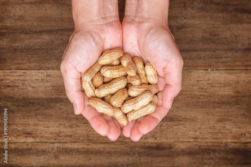Wallpaper Mural Opened female palms with fresh peanuts on wooden background Torontodigital.ca