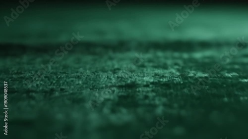 Dark green velvet fabric texture with folds and shadows close up
