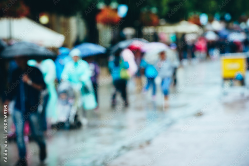 Obraz premium Pedestrians joyfully navigate puddles, sheltered by colorful umbrellas from the rain