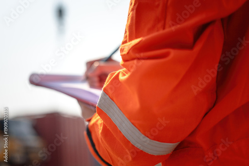 Foto Action of safety officer is writing and check on checklist document during safety audit and inspection at drilling site operation