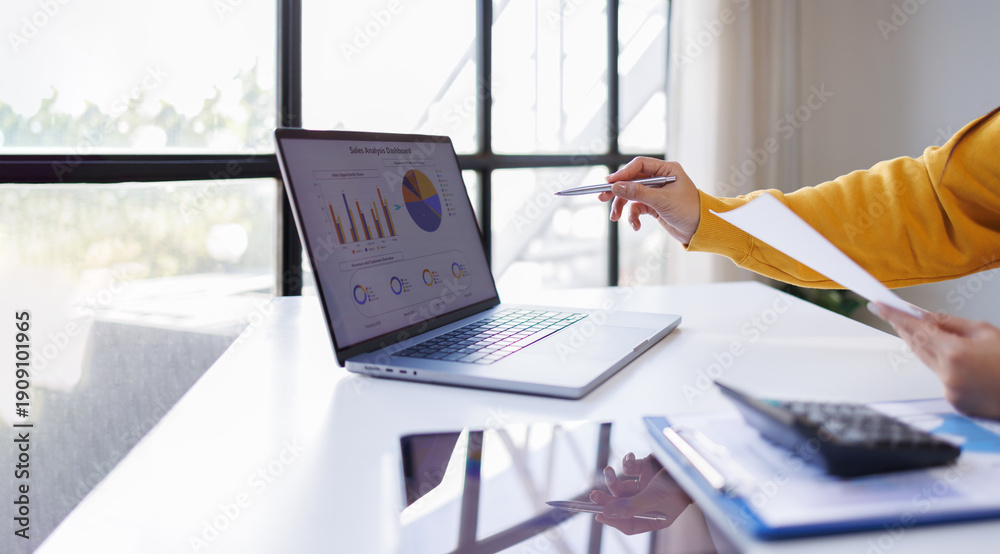 Εκτύπωση καμβά Focused businesswoman wearing glasses reads documents at a modern office desk, s