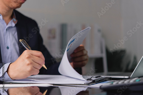 Foto Close up businessman hand holding pen signing contract paper document