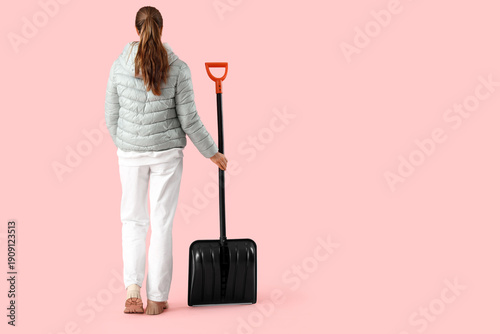Young woman with snow shove...