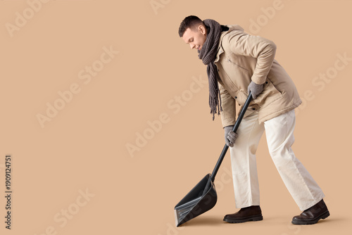 Young man with snow shovel ...