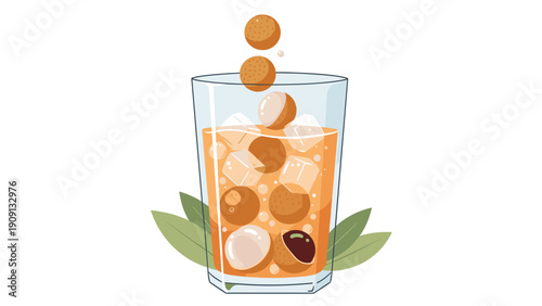 Tall glass of refreshing longan juice is filled with ice and several whole peeled longan fruits with fresh leaves.