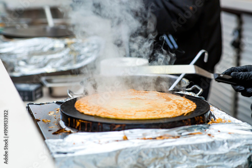 Canvas-taulu Cooking pancakes outdoors in a close-up with rising steam, which is timed to coincide with the arrival of spring and the Maslenitsa holiday