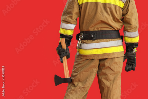 Male firefighter with axe o...
