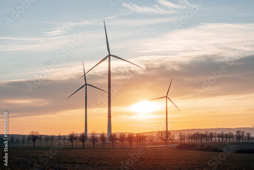 Scenic Wind Turbines in a Rural Landscape at Sunset, Silhouette of Wind Farm Against a Golden Hour Sky in Natural Light