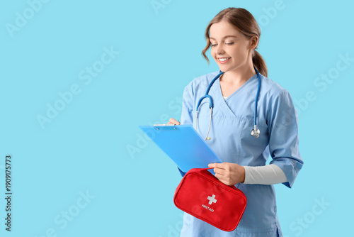 Female doctor with first aid kit and clipboard on blue background