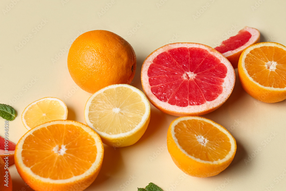 Fototapeta premium Different cut citrus fruits and mint leaves on beige background