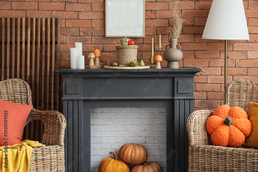 Fototapeta premium Fireplace, armchairs and pumpkins in autumn living room