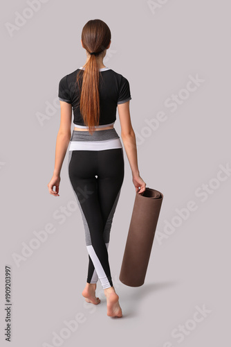 Young woman with yoga mat o...