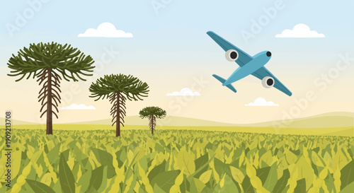 A blue airplane flies over a grassy field with pine trees