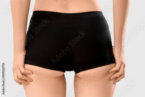 Beautiful young woman in underwear on blue background, back view. Concept of ...