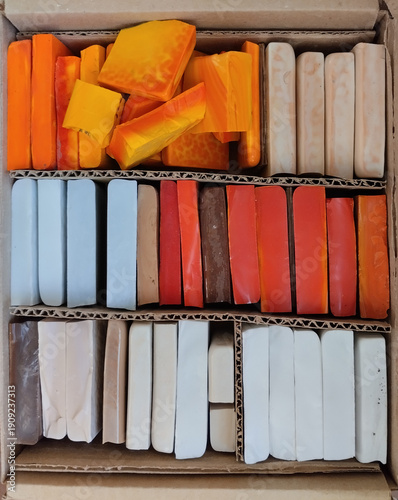 Colorful glass smalt bricks for mosaic art, organized in a box.  orange, yellow, white, red tiles for backgrounds, art materials, craft, DIY, artwork. decorative material 
