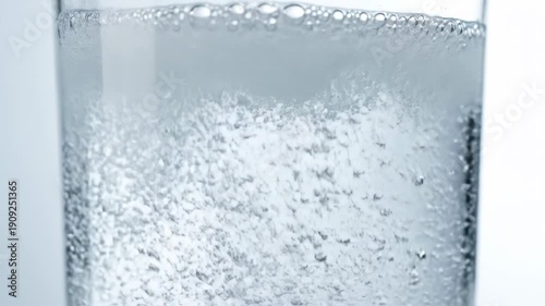 Clear beverage with abundant carbonation creating a foamy layer on top