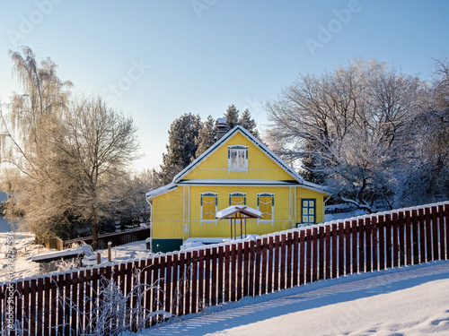 Photos yellow wooden house with carved architraves on the windows