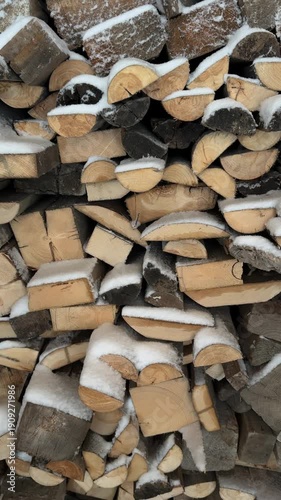 Stacked wood covered in snow, capturing the essence of rustic living and winter vibes. Perfect for projects related to winter seasons, forestry, and eco-friendly themes