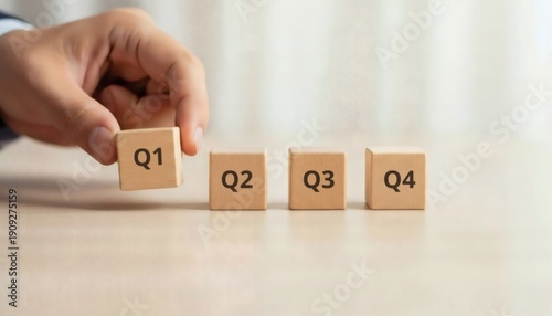 Strategic Goal Setting, wooden blocks in a horizontal row with quarterly targets Q1 Q2 Q3 Q4, business planning timeline and corporate performance roadmap.
