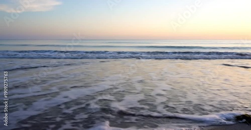 Gentle Ocean Waves Lapping on Sandy Beach at Sunrise