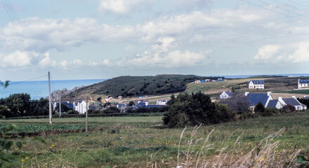 Leinwandbilder Khaki Erquy, Brittany, France, August 1982: rural coastal landscape with houses, fields and the sea in the background, everyday life and land use on the French coast in the early 1980s  © Bruno