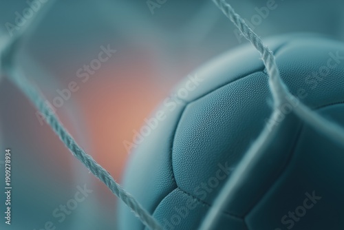 Soccer ball or handball hitting goal net, with blurred background, symbolizing sport and achievement