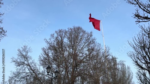 Kyrgyzstan flag waving on flagpole against blue sky, outdoor video