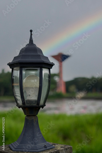 Outdoor Garden Lamp with Rainbow in Cloudy Sky
