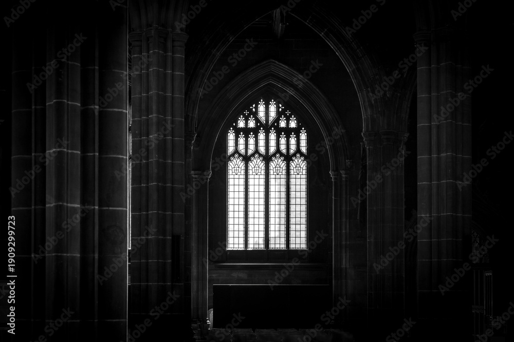 Obraz premium Gothic church window with stone columns in dark interior