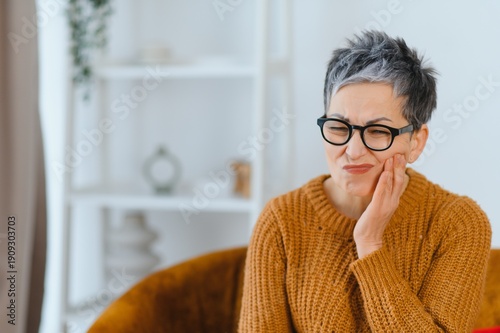 Photos Senior woman having toothache problem holding her cheek