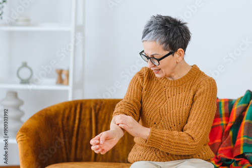 Photos Senior woman scratching arm having skin allergy reaction