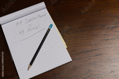 Visual metaphor of phone as human brain. Handwritten phrases representing digital existence. With copy space on the right for text.