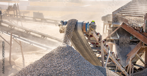 Vibrating screen stone crusher in operation. Crushing stones in a quarry for processing minerals, cement, limestone. Heavy and mobile equipment in a quarry for processing stone into building material.
