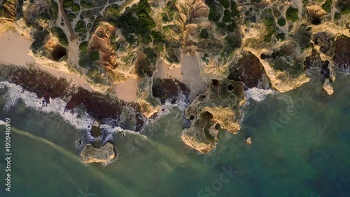 Aerial view of the Algarve coast where the cliffs meet the ocean, creating a beautiful contrast of textures and colors, Algarve, Faro District, Portugal.